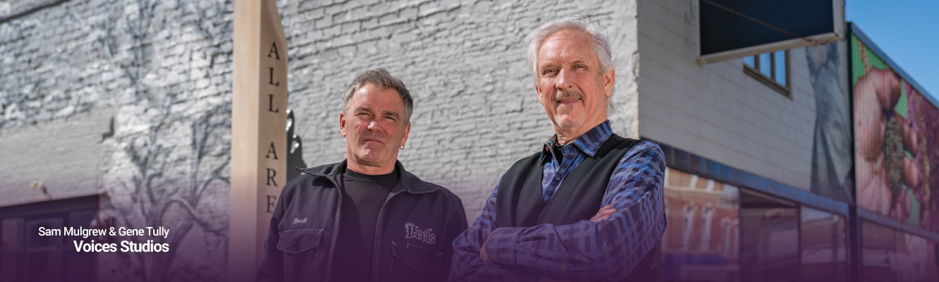 Sam Mulgrew and Gene Tully standing in front of Voices building