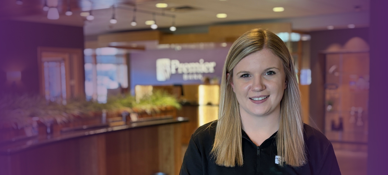 Image of Branch Manager standing in a Premier Bank lobby, smiling.